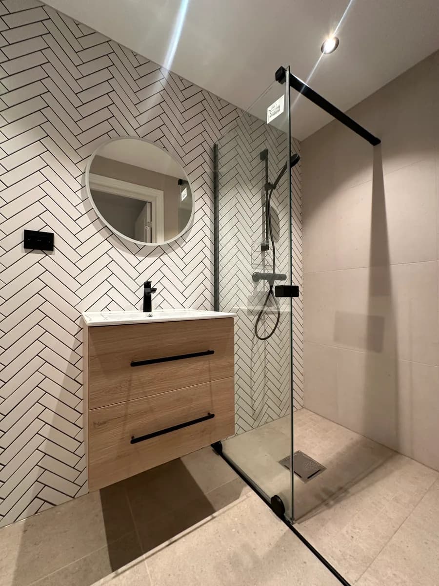 Lyst baderom med herringbone-fliser fra totalrenovert bolig